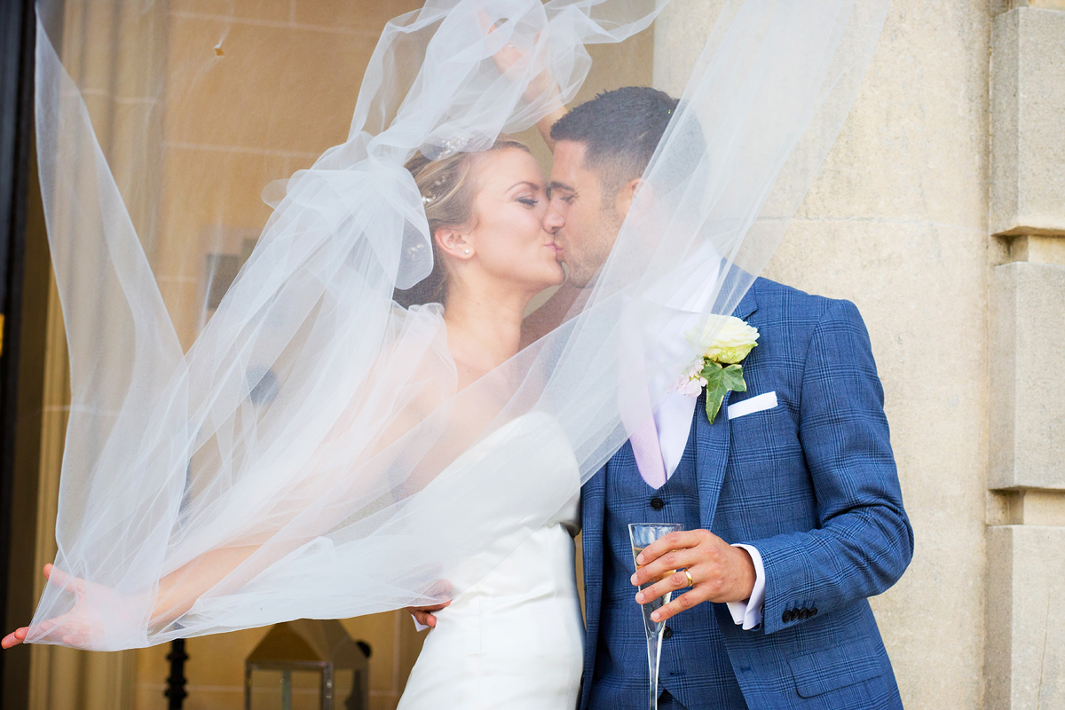 bride and groom kissing on hedsor house steps