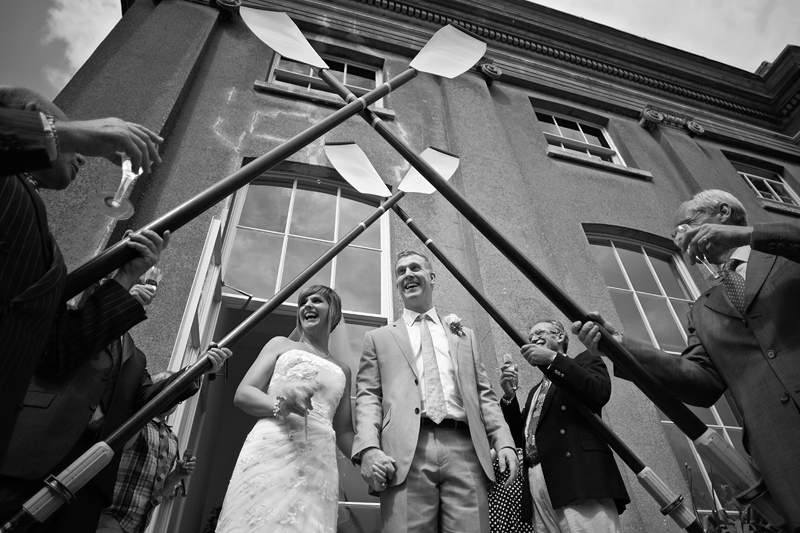 second wedding - bride and groom leave ceremony under oar arch